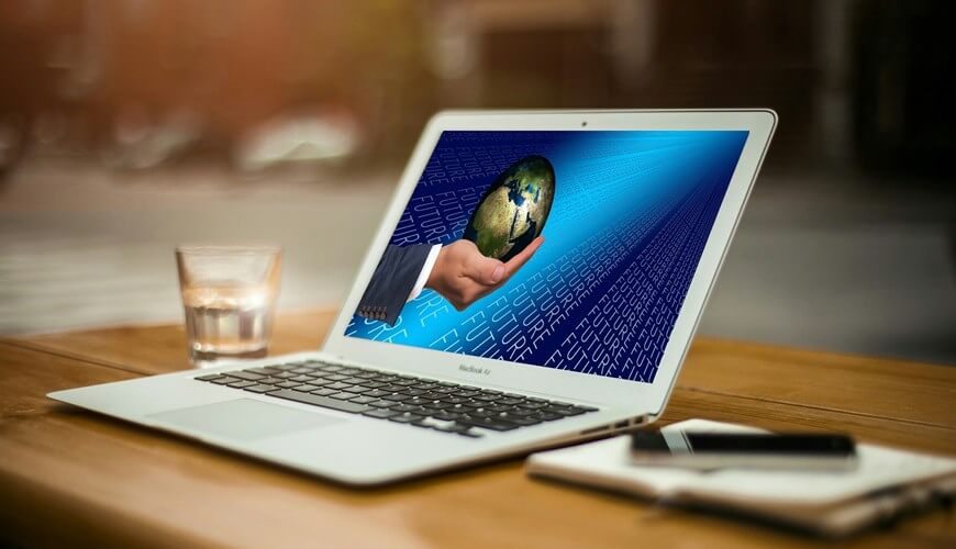 Čovek drži planetu u ruci, slika na laptopu